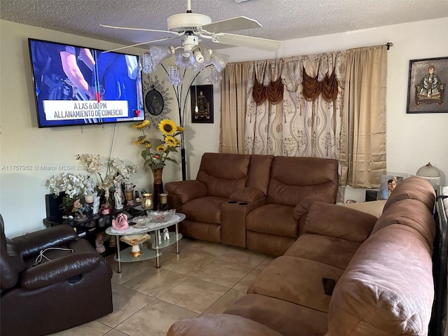 living room featuring tile patterned flooring, ceiling fan, and a textured ceiling