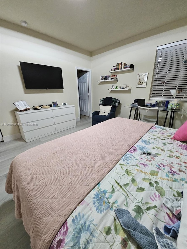 bedroom featuring baseboards and wood finished floors