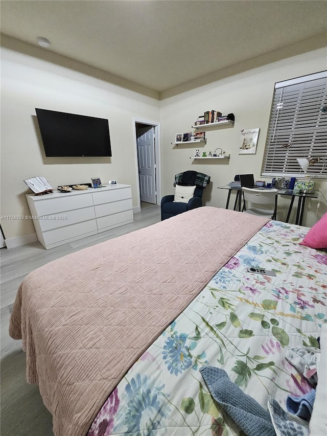 bedroom with wood finished floors and baseboards