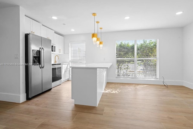 kitchen featuring recessed lighting, white cabinetry, light countertops, appliances with stainless steel finishes, and hanging light fixtures