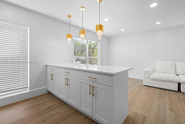 kitchen featuring a peninsula, light wood-type flooring, light countertops, and recessed lighting