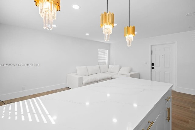 kitchen featuring decorative light fixtures, baseboards, wood finished floors, and recessed lighting