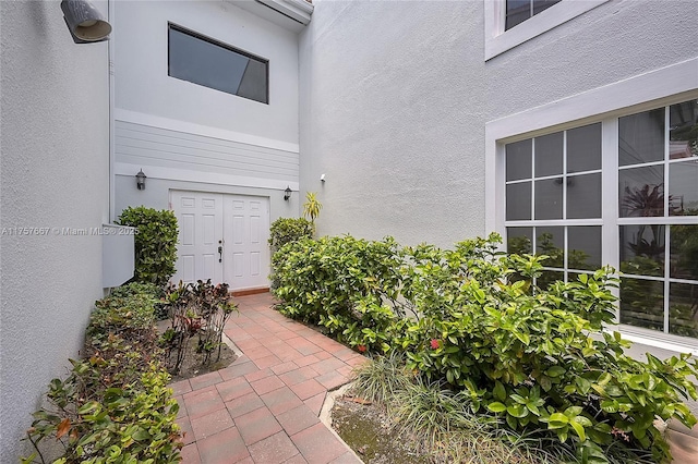 doorway to property featuring stucco siding