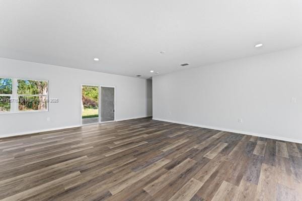 spare room featuring baseboards, wood finished floors, and recessed lighting