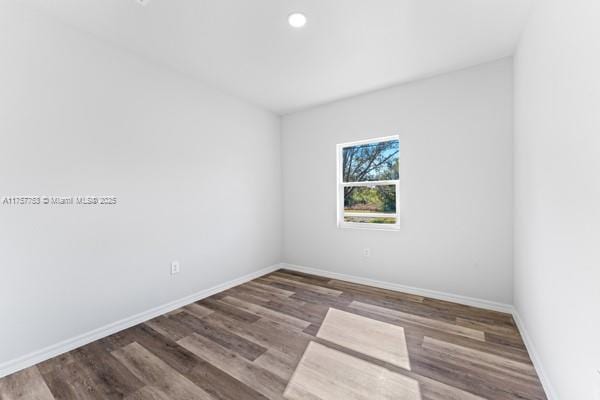 spare room featuring recessed lighting, baseboards, and wood finished floors