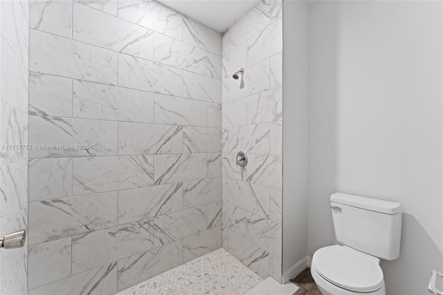 bathroom with tiled shower and toilet