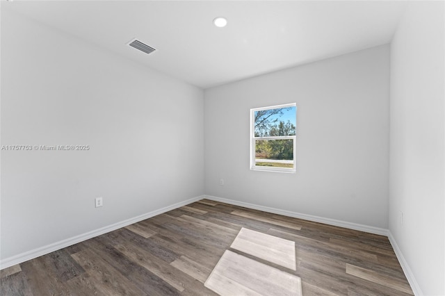 empty room featuring recessed lighting, wood finished floors, visible vents, and baseboards