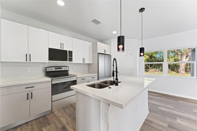 kitchen featuring electric stove, light wood finished floors, visible vents, white microwave, and a sink