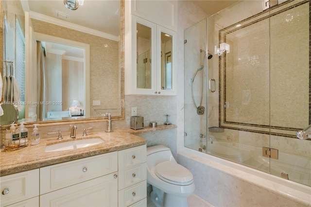 bathroom with shower / bath combination with glass door, tasteful backsplash, toilet, ornamental molding, and vanity