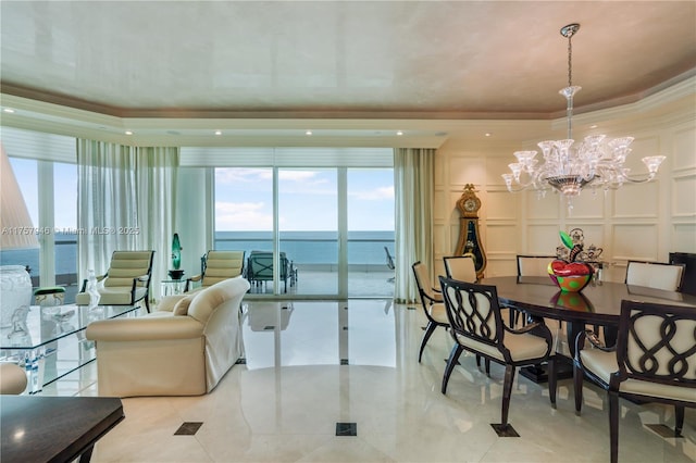 interior space featuring a tray ceiling, ornamental molding, an inviting chandelier, and a decorative wall