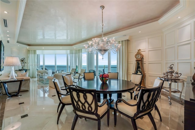 dining room with ornamental molding, a raised ceiling, visible vents, and a decorative wall