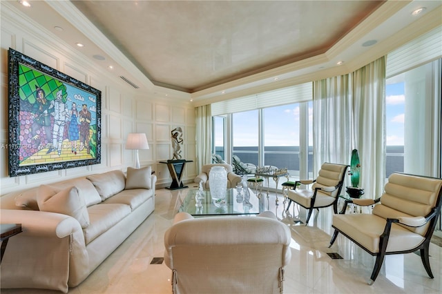 living area featuring recessed lighting, a decorative wall, visible vents, a tray ceiling, and crown molding