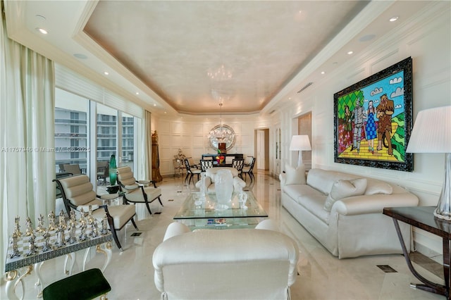 living area with ornamental molding, a tray ceiling, and a decorative wall