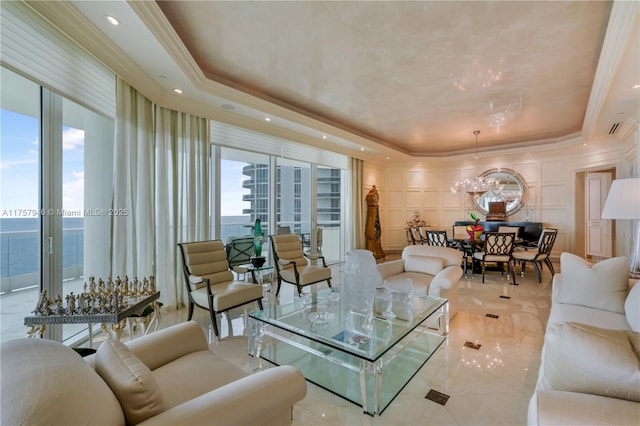 living room featuring ornamental molding, a raised ceiling, and a decorative wall