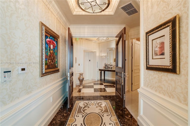 hall with a wainscoted wall, visible vents, and wallpapered walls