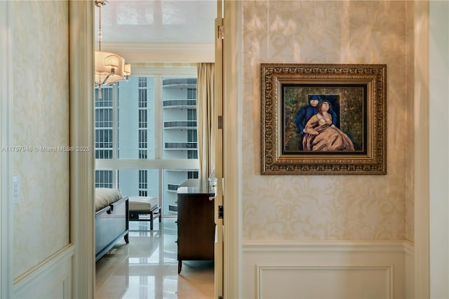 hallway featuring ornamental molding, a wainscoted wall, a decorative wall, and wallpapered walls