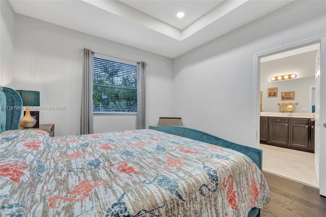 bedroom featuring light wood-type flooring and ensuite bathroom