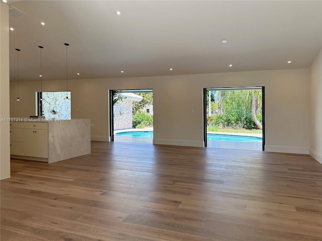 spare room featuring light wood-style floors, baseboards, and recessed lighting