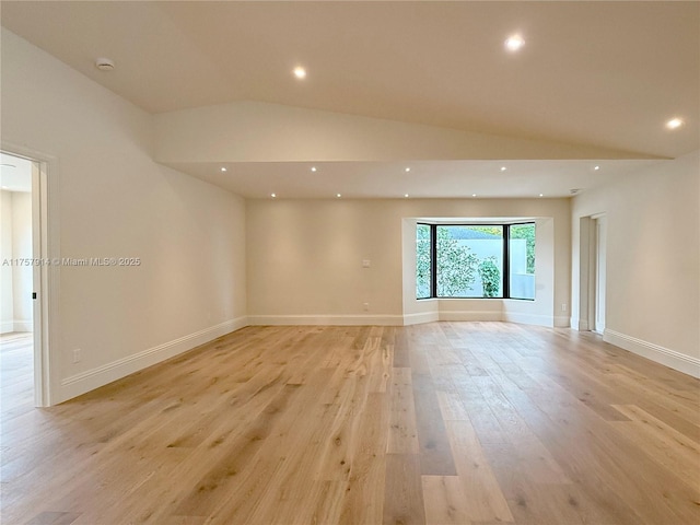 unfurnished room with lofted ceiling, light wood-style flooring, baseboards, and recessed lighting