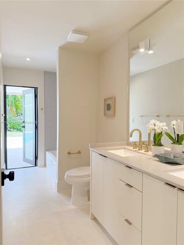 full bath with double vanity, a sink, toilet, and a tub