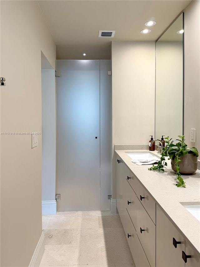 bathroom featuring double vanity, baseboards, visible vents, a sink, and recessed lighting