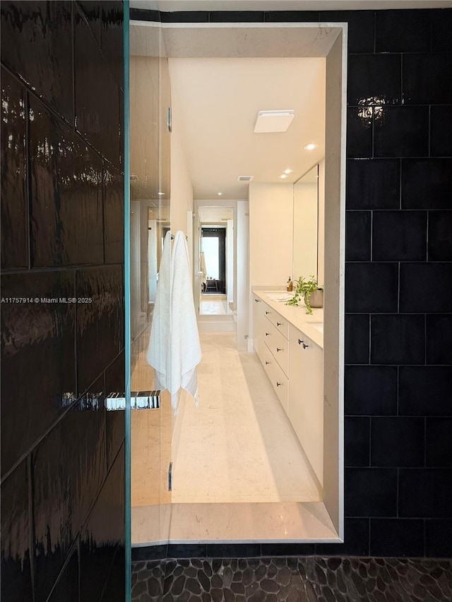 full bath featuring a walk in shower and vanity