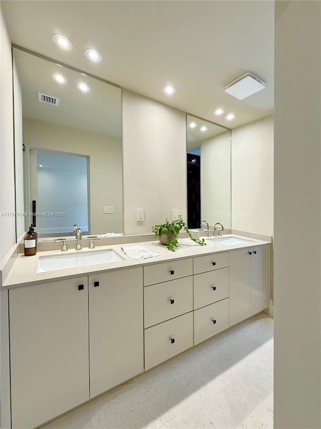 bathroom featuring recessed lighting, visible vents, a sink, and double vanity