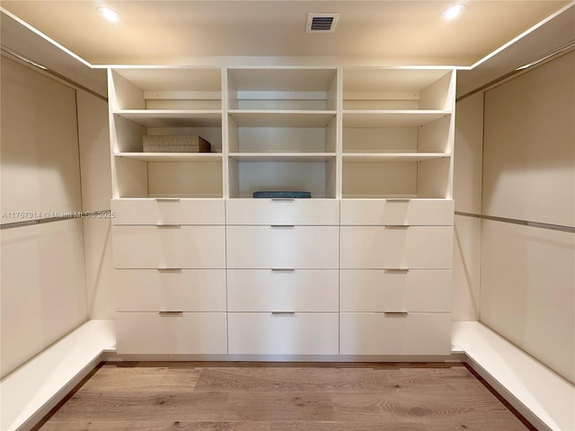 spacious closet featuring light wood-type flooring and visible vents