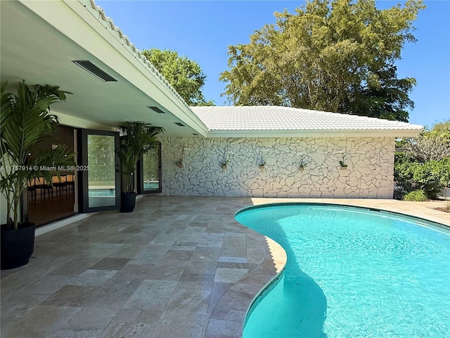 outdoor pool with a patio area