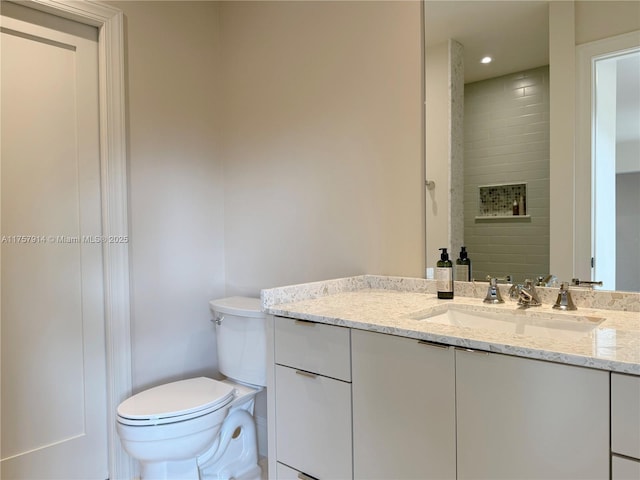 bathroom with vanity, toilet, and recessed lighting