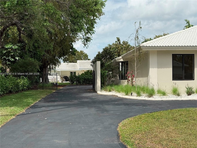 exterior space featuring a tile roof and stucco siding