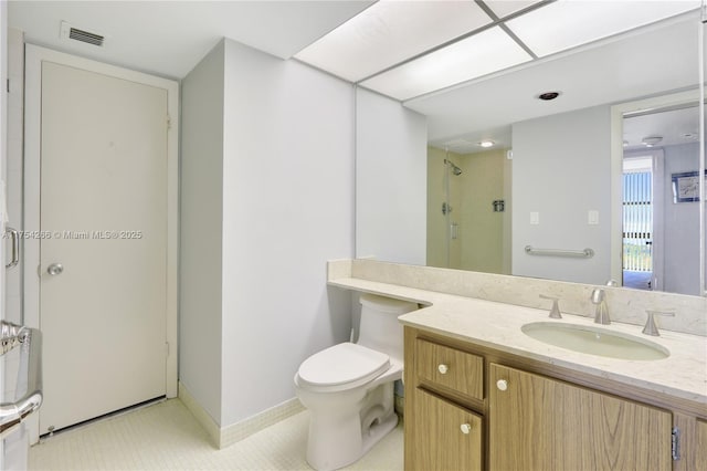 bathroom featuring visible vents, toilet, vanity, baseboards, and walk in shower