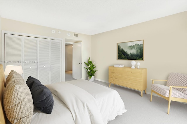 bedroom with light colored carpet, a closet, visible vents, and baseboards