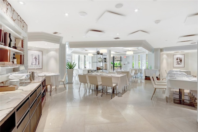 kitchen featuring visible vents, a breakfast bar, a center island, light stone countertops, and light tile patterned flooring