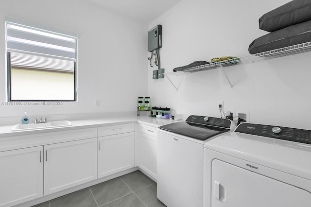 laundry room with light tile patterned floors, washing machine and dryer, a sink, and cabinet space