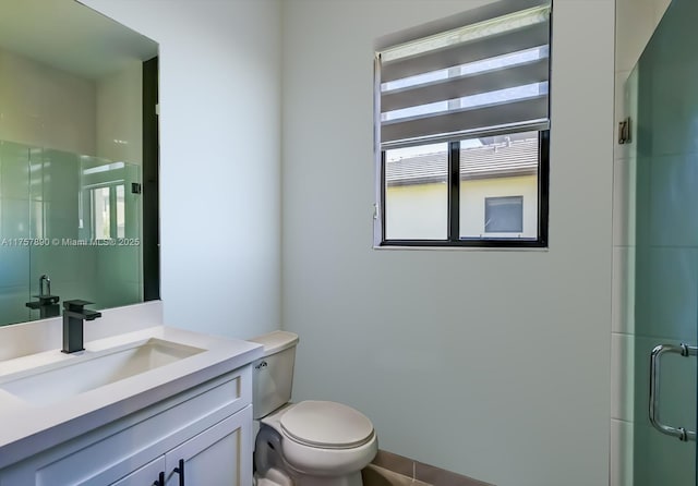 bathroom with toilet, a stall shower, and vanity