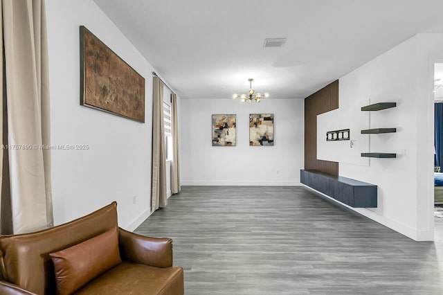 interior space with wood finished floors, visible vents, baseboards, and an inviting chandelier