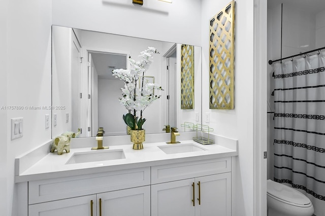 bathroom with a shower with curtain, a sink, toilet, and double vanity