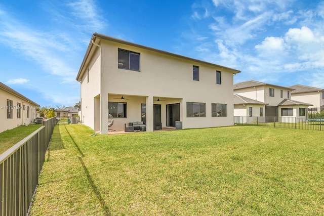 back of property featuring a yard, a fenced backyard, ceiling fan, and stucco siding