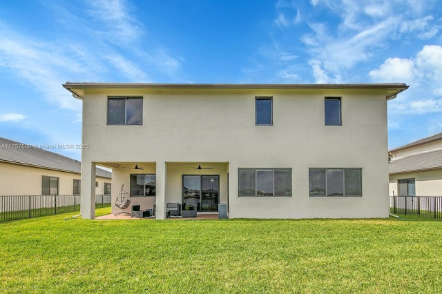 rear view of property with a ceiling fan, a fenced backyard, and a yard