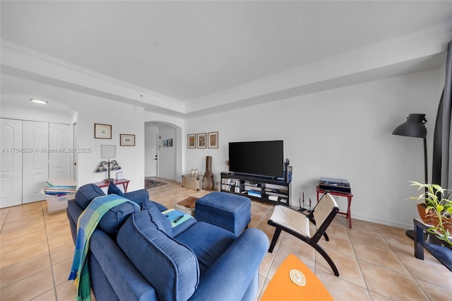 living area featuring arched walkways, a tray ceiling, light tile patterned floors, and crown molding