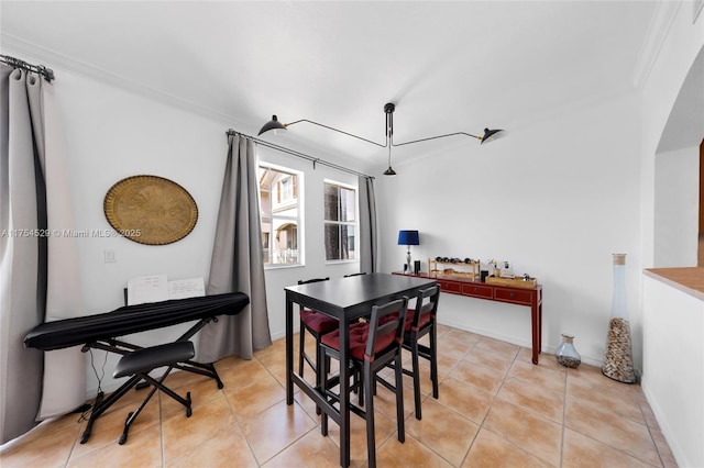 dining area featuring light tile patterned floors, baseboards, and crown molding