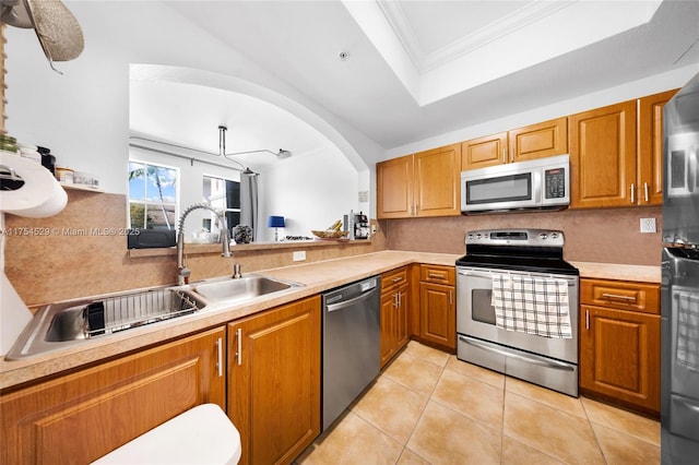 kitchen featuring crown molding, light countertops, appliances with stainless steel finishes, and decorative backsplash