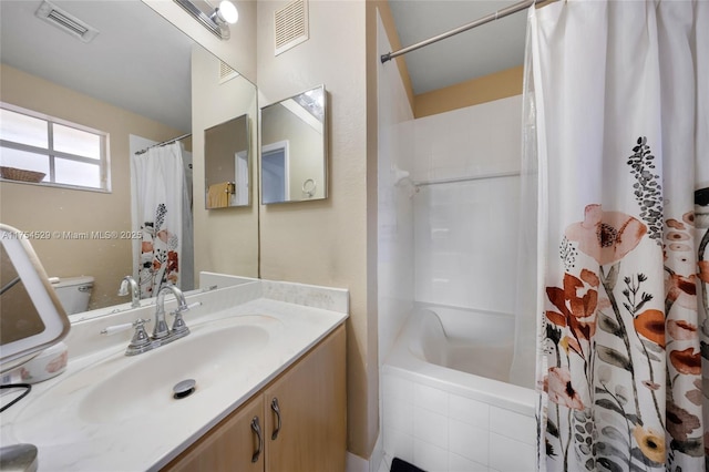 bathroom featuring toilet, shower / bath combo with shower curtain, vanity, and visible vents