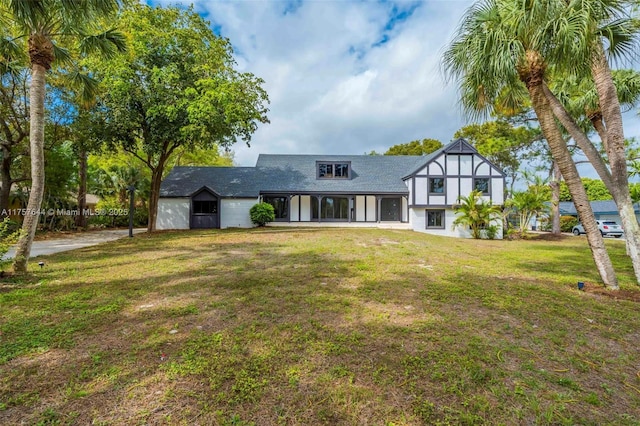 tudor-style house with a front lawn