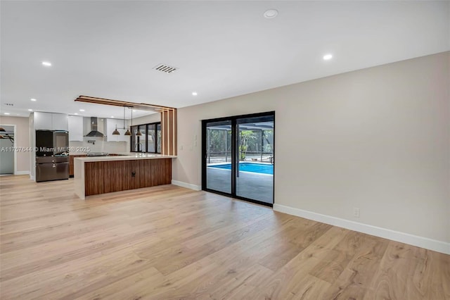 kitchen with light countertops, light wood-style flooring, open floor plan, modern cabinets, and a peninsula