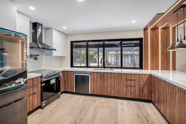 kitchen with a sink, wall chimney exhaust hood, modern cabinets, and electric stove