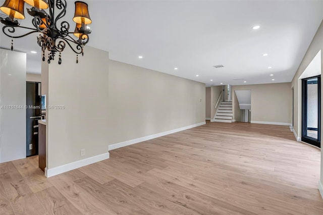 unfurnished room with recessed lighting, visible vents, baseboards, light wood-style floors, and stairway