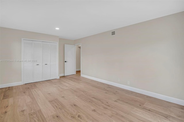 unfurnished bedroom featuring recessed lighting, a closet, visible vents, light wood-style flooring, and baseboards