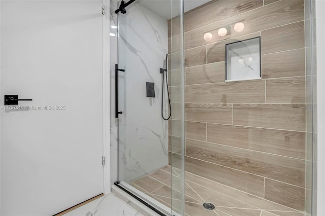 bathroom featuring a marble finish shower